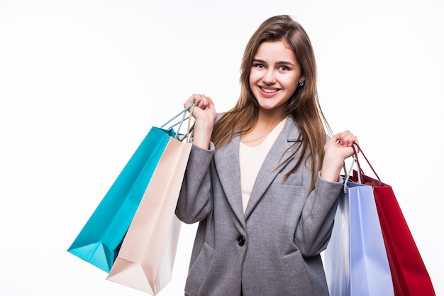 Portrait of young happy smiling woman with shopping bags over white background