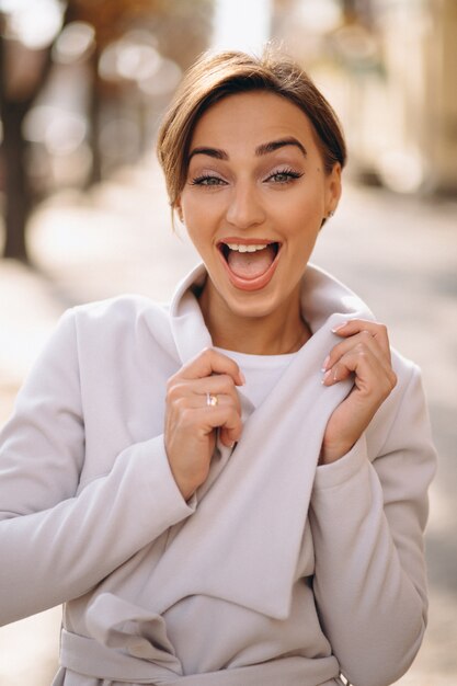 Portrait of a young happy woman in coat