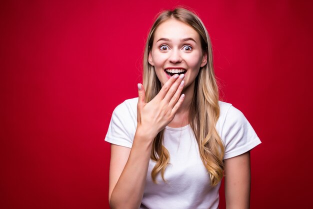 Portrait of young happy woman isolated over red wall