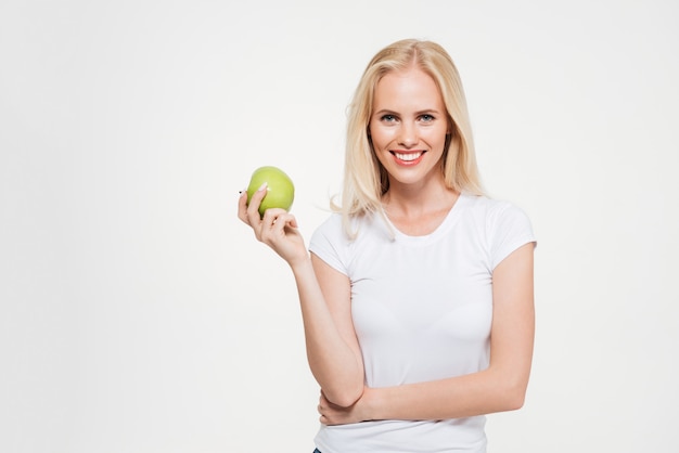 Портрет молодой здоровой женщины, держащей зеленое яблоко