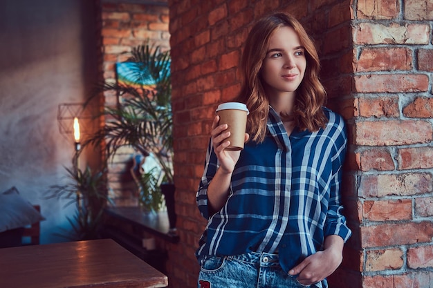 若い流行に敏感な女の子の肖像画は、朝のコーヒーを飲みます。