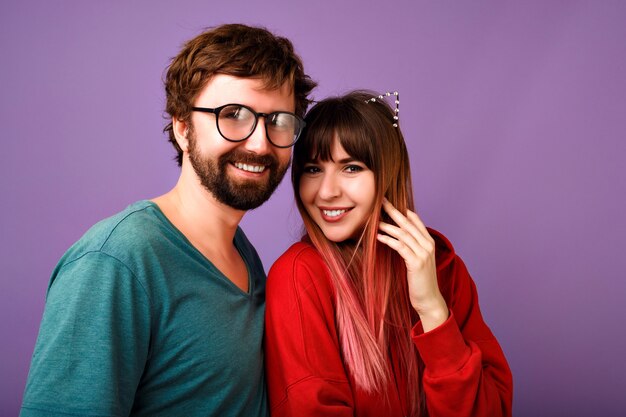 portrait of young hipster pretty family couple hugs, wearing trendy casual outfits, boyfriends and girlfriends, relation goals, violet wall