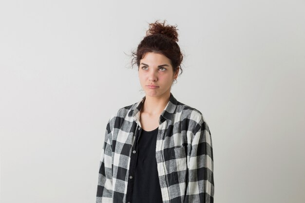 Portrait of young hipster pretty woman in checkered shirt thinking, having a problem, posing isolated on white studio background