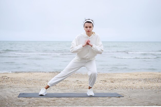 Портрет юной леди, занимающейся медитацией на пляже Фото высокого качества