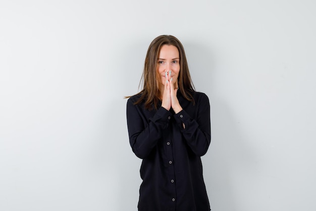 Portrait of young lady holding hands in praying gesture