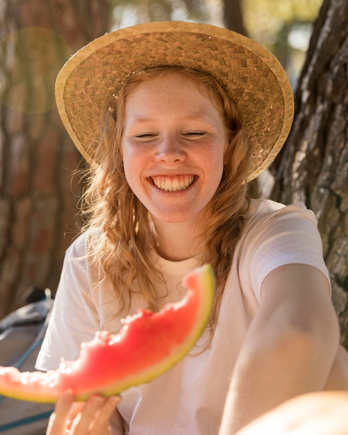 Foto gratuita ritratto di giovane donna che tiene una fetta di anguria