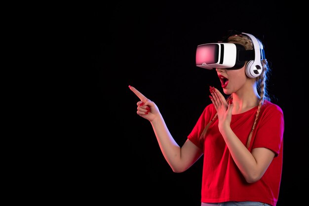 暗い床の視覚的な超音波でヘッドフォンでVRを再生する若い女性の肖像画