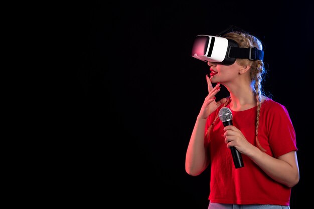 Portrait of young lady playing vr and singing on a dark  music ultrasound game visual