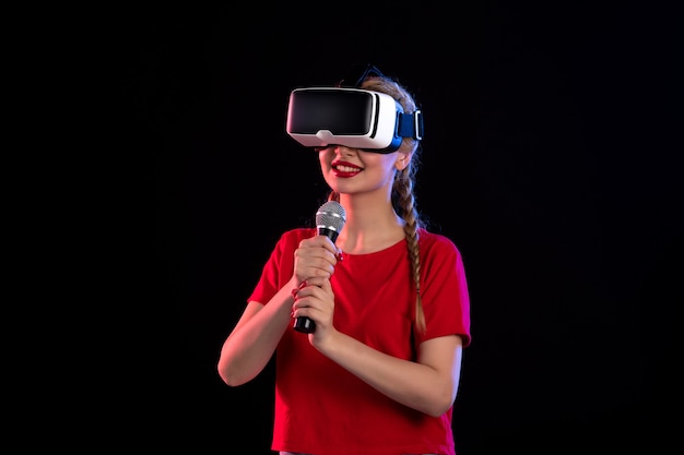 Portrait of young lady playing vr and singing on the dark  music visual ultrasound game