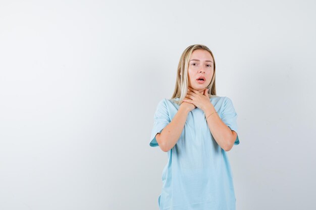 Portrait of young lady suffering from throat pain in t-shirt isolated