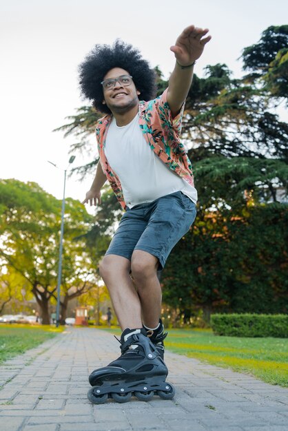 Портрет молодого латинского человека, практикующего навыки во время катания на роликах на открытом воздухе на улице. Спортивная концепция. Городская концепция.