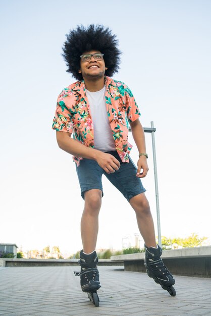 Portrait of young latin man rollerskating outdoors on the street. Sports concept. Urban concept.