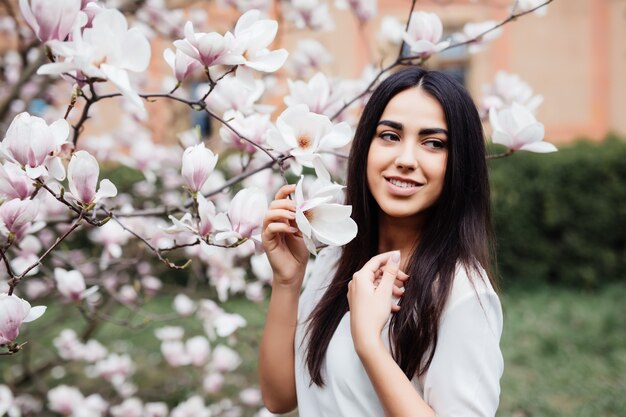 Портрет молодой прекрасной женщины весной цветы цветут дерево магнолии
