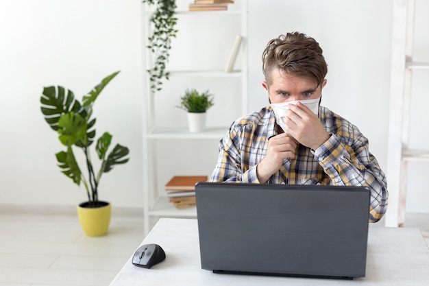 Portrait of young male arranging face mask