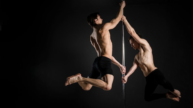 Portrait of young male doing a pole dance