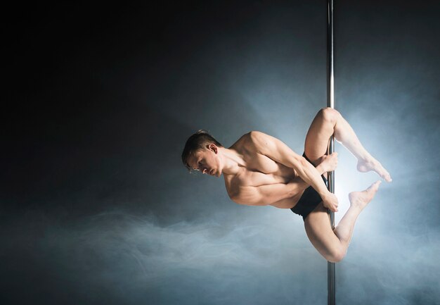 Portrait of young male model pole dancing