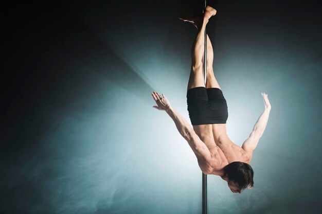 Portrait of young male model pole dancing