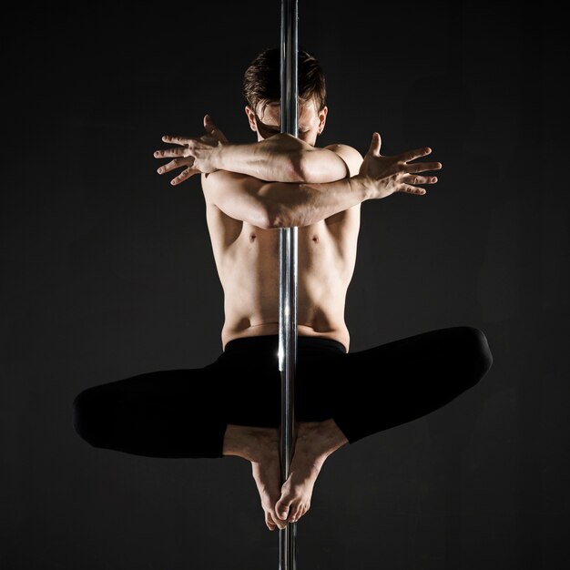 Portrait of young male model pole dancing