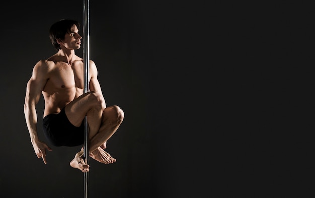 Portrait of young male model pole dancing