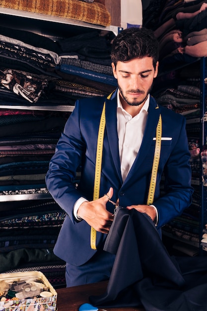 Free photo portrait of a young male tailor working in his workshop