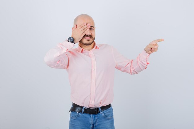 Portrait of a young man covering his eye