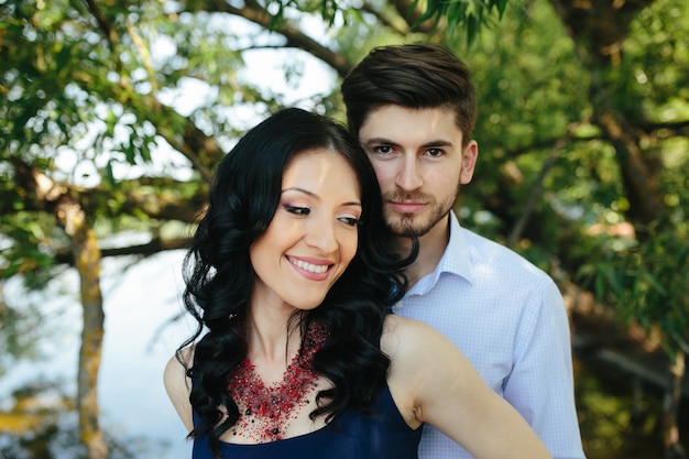 Portrait of a young man embracing his girlfriend from behind