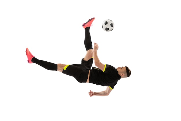 Portrait of young man football playing in motion training isolated over white studio background