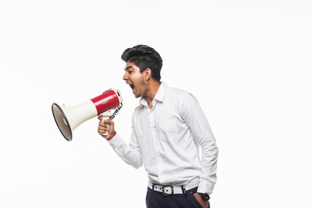 Portrait of young man handsome shouting using megaphone isolated on white wall