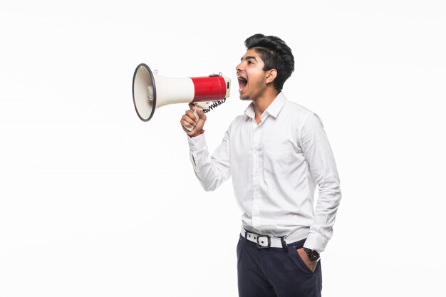 Portrait of young man handsome shouting using megaphone isolated on white wall