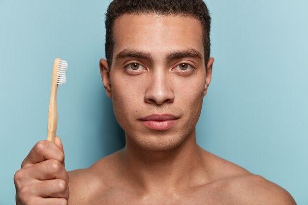 Portrait of young man holding toothbrush