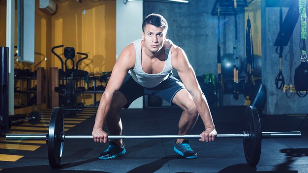 Portrait of a young man lifting barbell