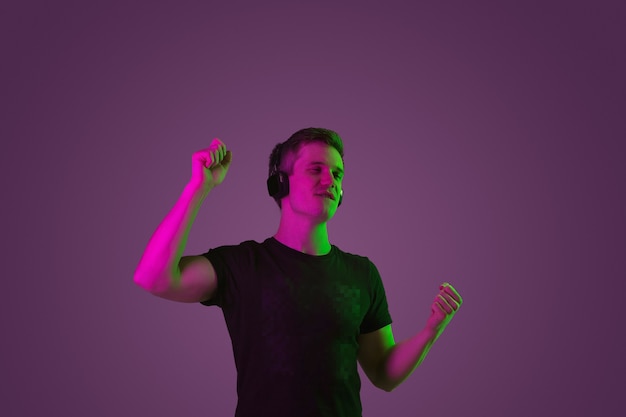 Portrait of young man listening to music with neon lights