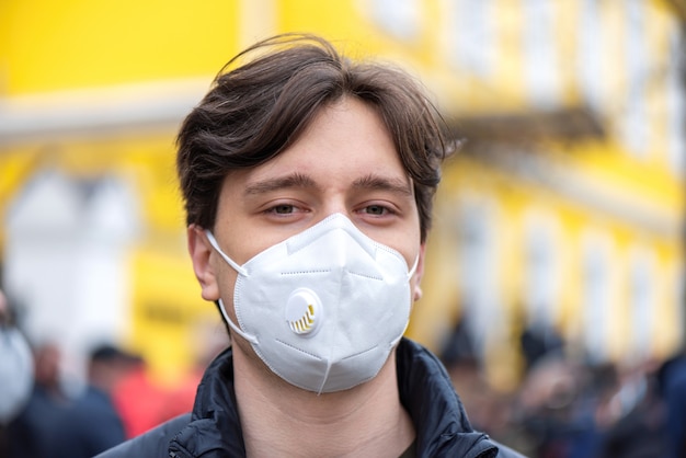 Free photo portrait of a young man in medical mask, people protesting for snap elections in front of constitutional court building, chisinau, moldova