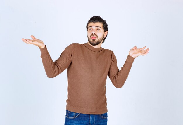 Portrait of a young man model with beard standing and posing with hands . High quality photo