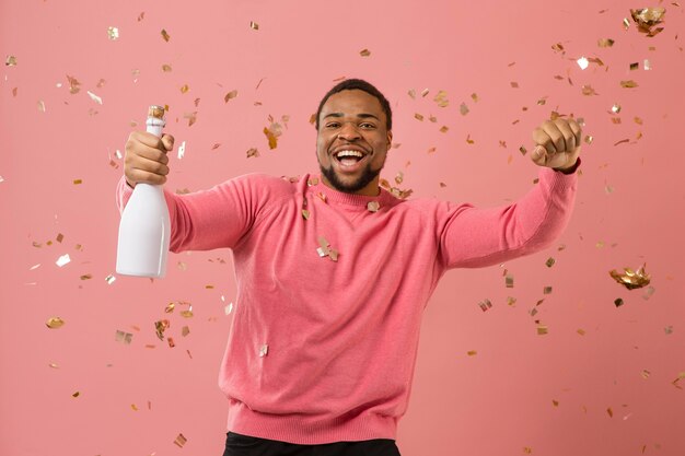 Portrait young man at party with champagne bottle