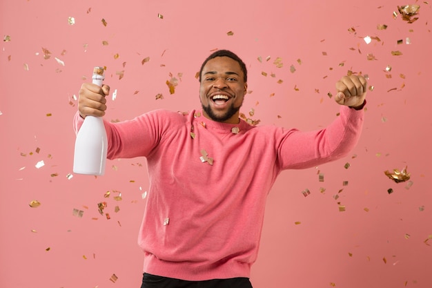 Портрет молодого человека на вечеринке с бутылкой шампанского