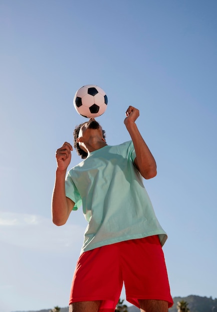 Foto gratuita ritratto giovane che gioca a calcio