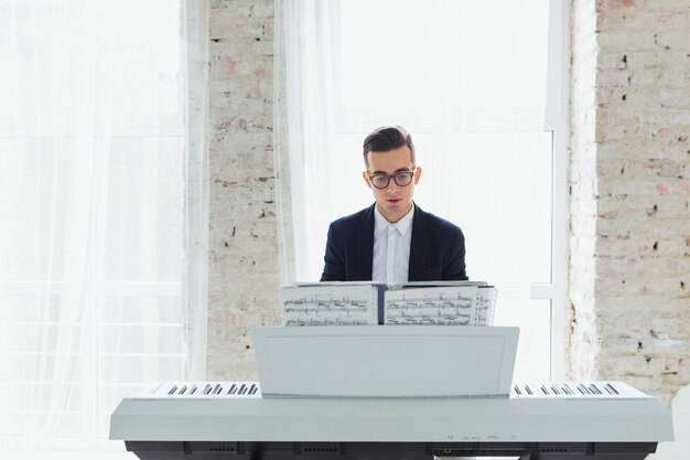 Портрет молодого человека, играющего на пианино, сидящего перед окном