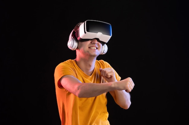 暗い壁にヘッドフォンで vr をしている若い男の肖像