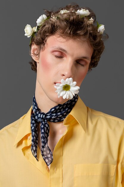 Portrait young man posing with floral wreath