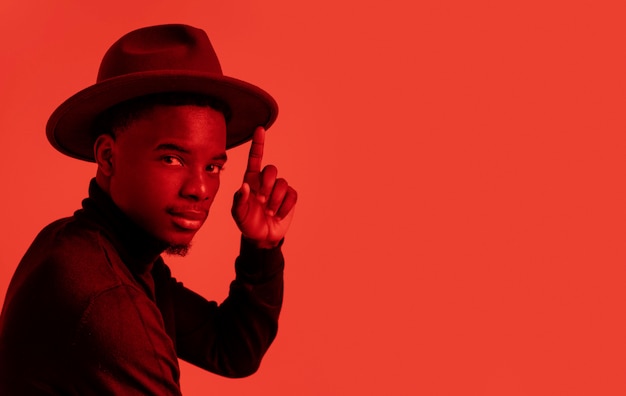 Free photo portrait young man posing with hat