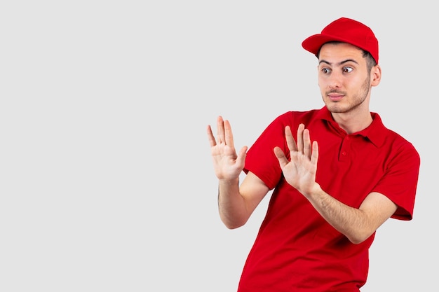 Free photo portrait of young man in red uniform staying away from something