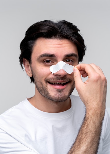 Portrait of a young man removing his nose patch