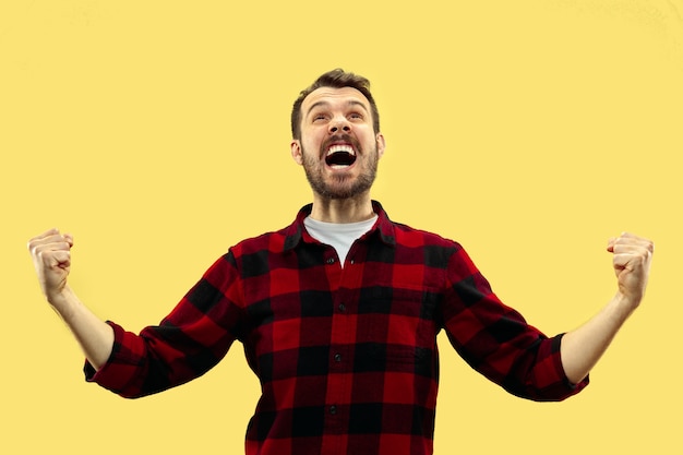 portrait of young man in shirt.Front view. Trendy colors. Celebrating as a winner or champion.