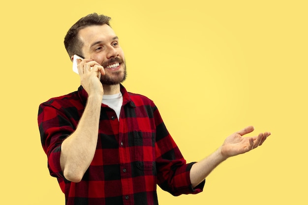 Free photo portrait of young man in shirt.front view. trendy colors. talking on the phone.