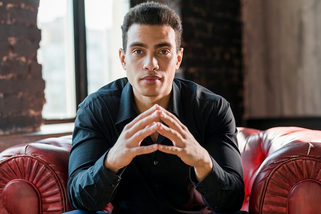 Portrait of a young man sitting on armchair