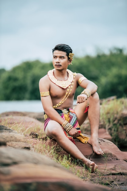 태국에서 자연 속에서 포즈를 취하는 전통 의상을 입은 젊은 남자의 초상화