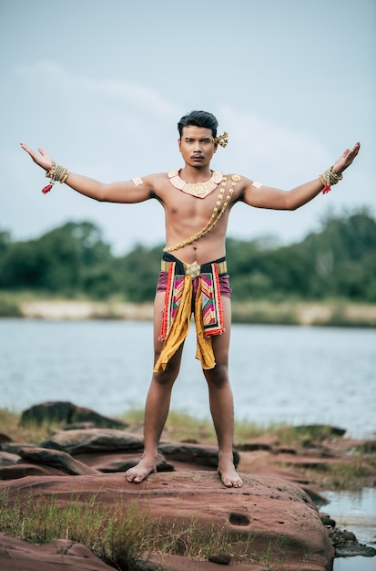 Portrait of Young man in traditional costume posing in nature in Thailand