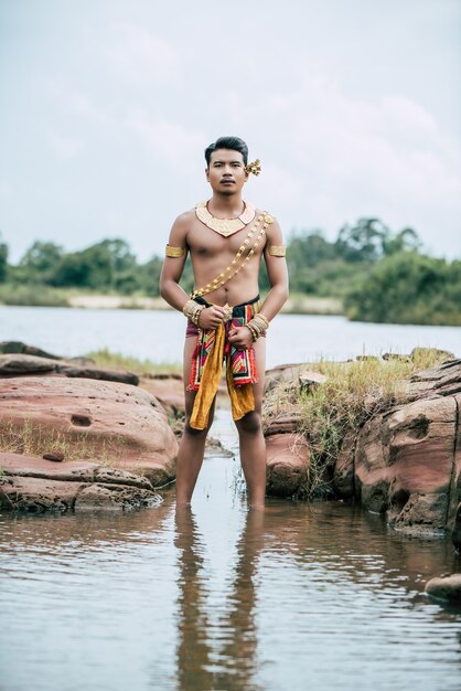 Portrait of Young man in traditional costume posing in nature in Thailand