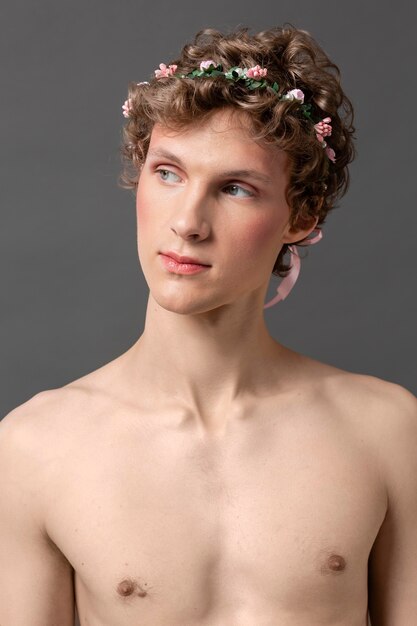 メイクと花の花輪を身に着けている肖像画の若い男